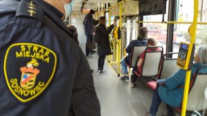 strażnicy miejscy z policjantami kontrolują autobusy