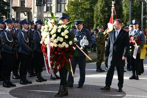 Goście biorący udział w uroczystości zmierzają w stronę pomnika, by złożyć kwiaty