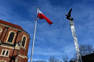 Biało-czerwona flaga Polski oraz pomnik