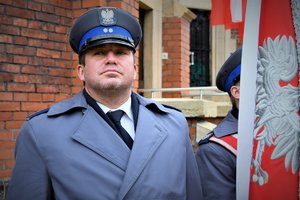 Kolorowe zdjęcie. Policjant z pocztu sztandarowego.