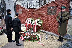 Kolorowe zdjęcie. Delegacja uczniów klasy mundurowej składa kwiaty.