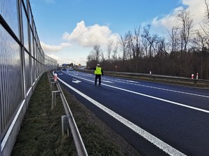 Widoczni policjanci i uczestnicy działań podczas kontroli autokarów przy autostradzie DK 81 w Ochabach Małych (zjazd na Wiślicę)