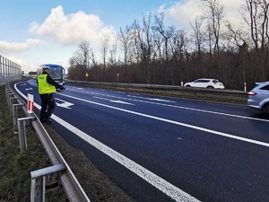 Widoczni policjanci i uczestnicy działań podczas kontroli autokarów przy autostradzie DK 81 w Ochabach Małych (zjazd na Wiślicę)