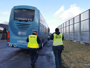 Widoczni policjanci i uczestnicy działań podczas kontroli autokarów przy autostradzie DK 81 w Ochabach Małych (zjazd na Wiślicę)