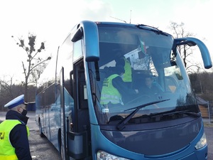 Widoczni policjanci i uczestnicy działań podczas kontroli autokarów przy autostradzie DK 81 w Ochabach Małych (zjazd na Wiślicę)