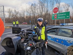 Widoczni policjanci i uczestnicy działań podczas kontroli autokarów przy autostradzie DK 81 w Ochabach Małych (zjazd na Wiślicę)