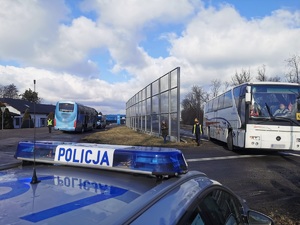 Widoczni policjanci i uczestnicy działań podczas kontroli autokarów przy autostradzie DK 81 w Ochabach Małych (zjazd na Wiślicę)