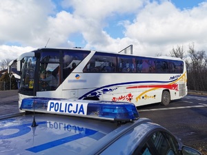 Widoczni policjanci i uczestnicy działań podczas kontroli autokarów przy autostradzie DK 81 w Ochabach Małych (zjazd na Wiślicę)