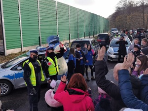 Widoczni policjanci i uczestnicy działań podczas kontroli autokarów przy autostradzie DK 81 w Ochabach Małych (zjazd na Wiślicę)