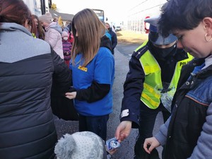 Widoczni policjanci i uczestnicy działań podczas kontroli autokarów przy autostradzie DK 81 w Ochabach Małych (zjazd na Wiślicę)