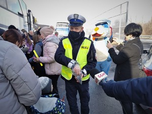 Widoczni policjanci i uczestnicy działań podczas kontroli autokarów przy autostradzie DK 81 w Ochabach Małych (zjazd na Wiślicę)