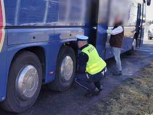 Widoczni policjanci i uczestnicy działań podczas kontroli autokarów przy autostradzie DK 81 w Ochabach Małych (zjazd na Wiślicę)