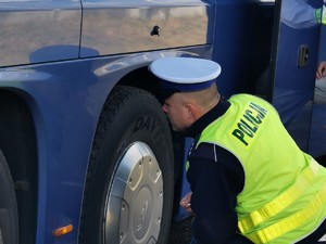 Widoczni policjanci i uczestnicy działań podczas kontroli autokarów przy autostradzie DK 81 w Ochabach Małych (zjazd na Wiślicę)