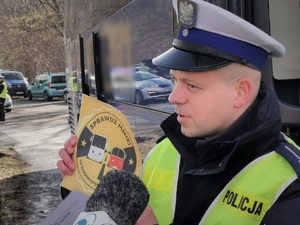 Widoczni policjanci i uczestnicy działań podczas kontroli autokarów przy autostradzie DK 81 w Ochabach Małych (zjazd na Wiślicę)