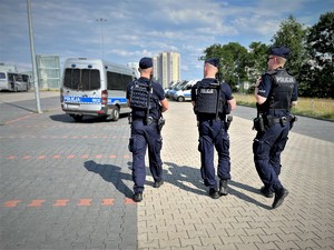 policjanci w trakcie patrolu, w tle radiowozy