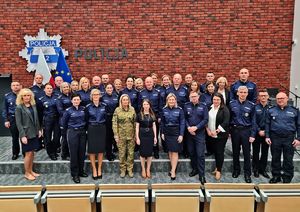 Grupowe zdjęcie uczestników konferencji. Większość osób to umundurowani policjanci.