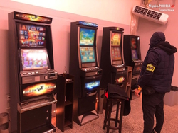 policjant stoi przy automatach do gier hazardowych