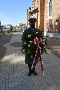 Policjant niosący wieniec