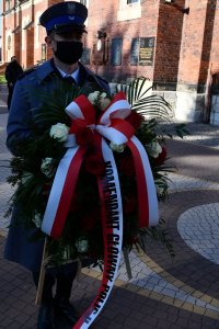 Policjant niosący wieniec