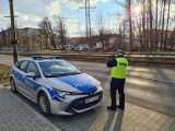 policjant mierzący prędkość . W tle radiowóz