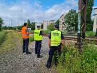 policjantka strażnik i pracownik kolei przy przejeździe