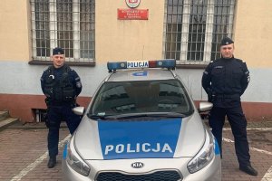 policjanci na tle radiowozu