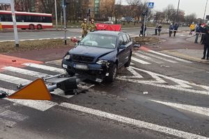 policjanci pracują na miejscu wypadku - uszkodzone auto