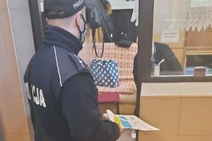 policjant rozmawia z recepcjonistką hotelu robotniczego i przekazuje ulotki