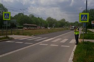 policjant mierzy prędkość w pobliżu przejścia dla pieszych