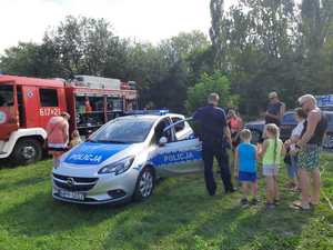 policjant pokazuje dzieciom radiowóz