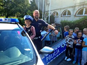 policjant pokazuje dzieciom radiowóz