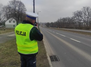 Zdjęcie przedstawia policjanta z Wydziału Ruchu Drogowego KMP Sosnowiec podczas pomiaru prędkości.
