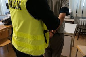 Zdjęcie przedstawia umundurowanego policjanta z zatrzymanym.