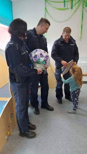 Zdjęcie przedstawia policjantów i dziecko.
