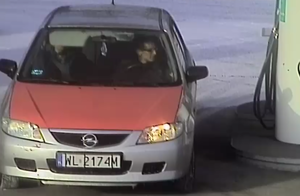 Zdjęcie przedstawia dwóch mężczyzn siedzących w samochodzie Opel Astra na stacji benzynowej.