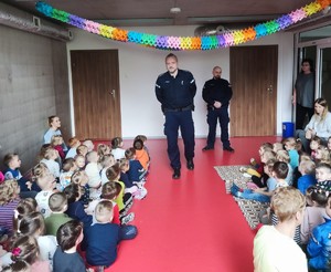 Zdjęcie przedstawia umundurowanych policjantów  w gronie przedszkolaków.