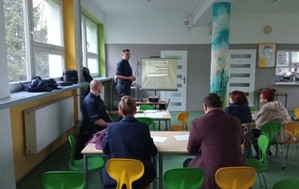 Zdjęcie przedstawia policjantów i uczestników debaty społecznej.