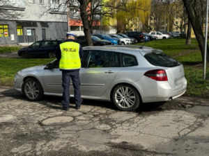 Zdjęcie przedstawia umundurowanego policjanta kontrolującego kierującego pojazdu.