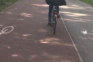 Zdjęcie przedstawia rowerzystę poruszającego się po ścieżce rowerowej.