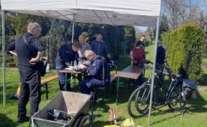 Zdjęcie przedstawia policjantów znakujących przedmioty. W tle kilku uczestników akcji.