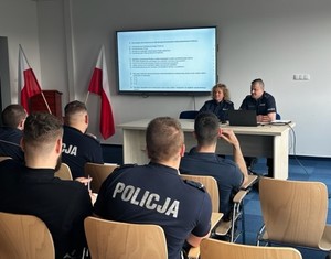 Zdjęcie przedstawia umundurowanych policjantów Ruchu Drogowego rozwiązujących test wiedzy.