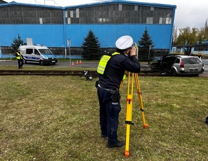 Zdjęcie przedstawia umundurowanego policjanta w trakcie pomiarów.