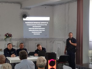 Zdjęcie przedstawia umundurowanych policjantów przemawiających do uczestników debaty.