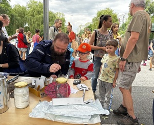 Zdjęcie przedstawia dziecko oraz technika kryminalistyki.