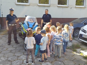 Zdjęcie przedstawia umundurowanych policjantów z grupą dzieci.