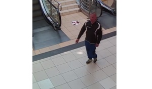 Zdjęcie przedstawia mężczyznę w ciemnej bluzie oraz granatowych spodniach na terenie sklepu.