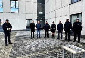 Zdjęcie przedstawia uczestników uroczystości na placu wewnętrznym oraz Komenda Miejskiego Policji w Sosnowcu.