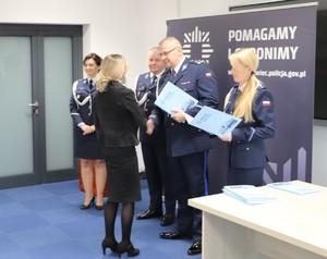 Zdjęcie przedstawia Komendanta Miejskiego Policji w Sosnowcu wraz z Zastępcami wręczających dyplom pracownicy.