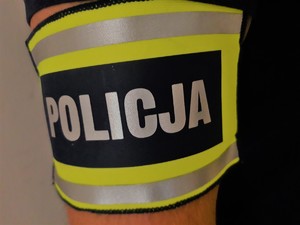 zdjęcie przedstawia opaskę z napisem policja