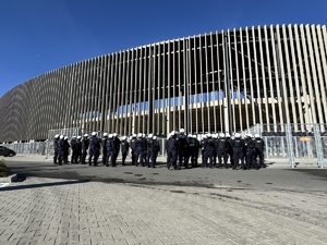 Zdjęcie przedstawia umundurowanych policjantów przy obiekcie sportowym.